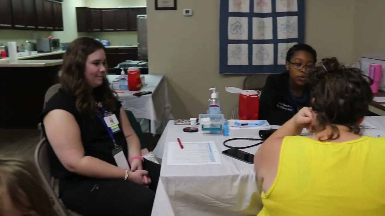 People seated together at a health service table in a frame from the event video