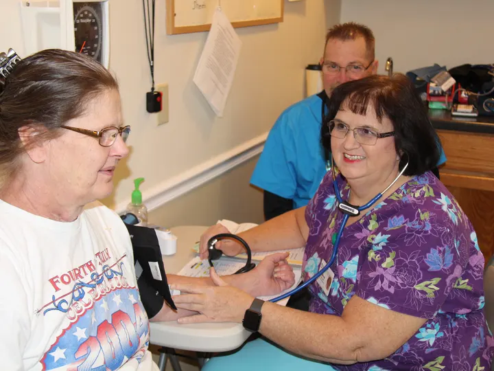 A medical volunteer caring for a patient at a clinic